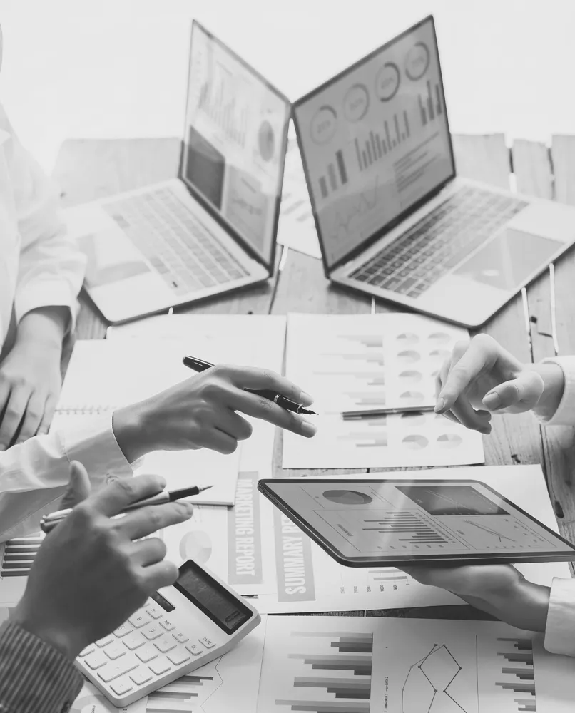 Group with laptops and papers around conference table