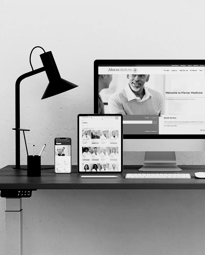 A computer, tablet, and phone on desk